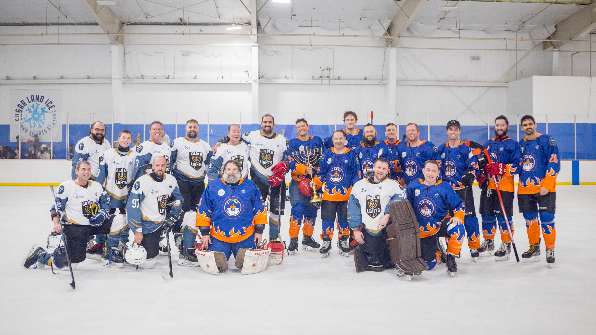 Both teams pose together at a past community hockey event