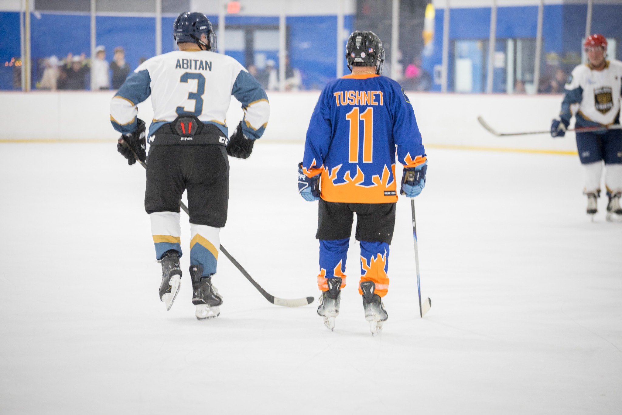 Two community hockey players skating at Sugar Land Ice Rink